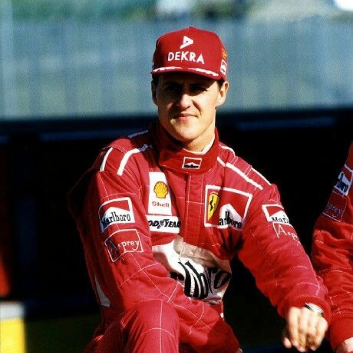 Close-up of Schumacher’s 1997 F1 race suit, displaying detailed stitching and rich red fabric, with sponsor logos highlighting his drive during the 1997 season.