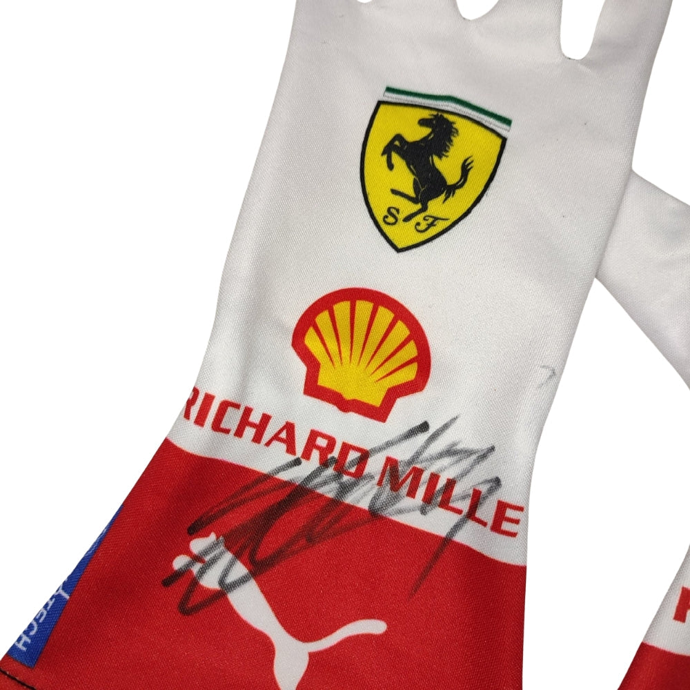 Close-up of a Charles Leclerc 2023 Monaco GP F1 Racing glove with Ferrari, Shell, and Richard Mille logos on a white background.