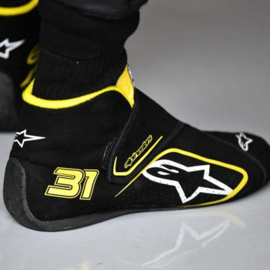 Black and yellow Esteban Ocon 2020 Tuscan GP F1 Racing shoe cover with number 31 and star logo on a gray background