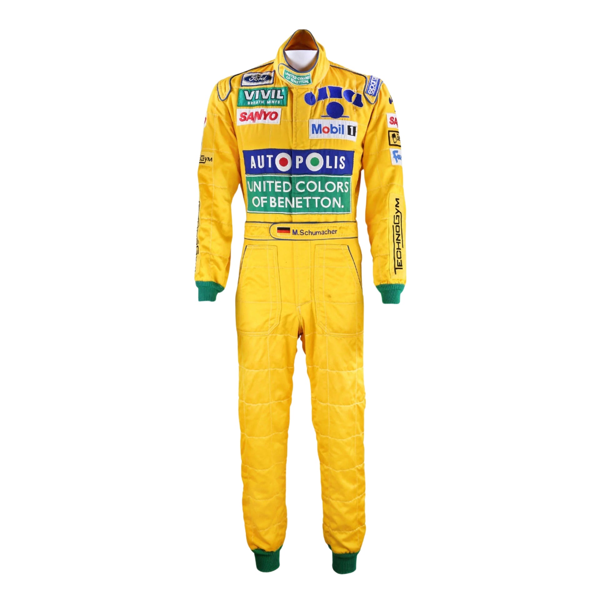 Front view of Michael Schumacher's 1992 F1 racing suit featuring deep green with yellow accents, signature Benetton sponsorship, and classic zip-front design.