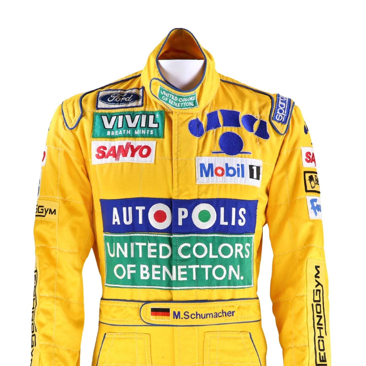 Close-up of the embroidered logos, stitching details, and breathable fabric textures from Michael Schumacher’s 1992 Benetton F1 race suit.