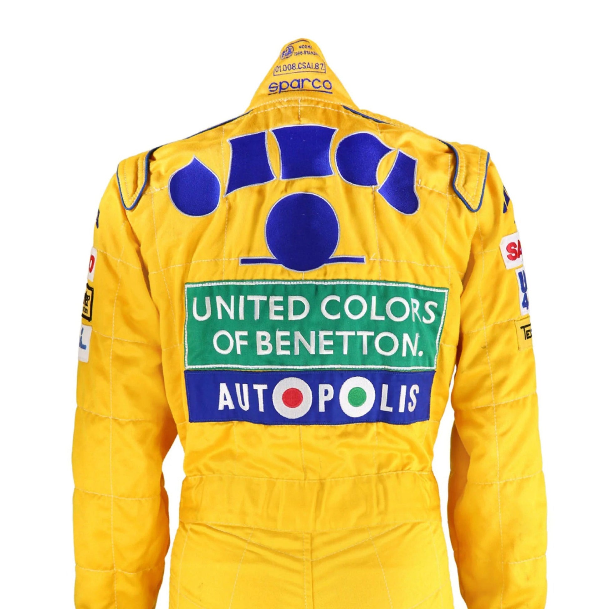 Back side of the 1992 Formula 1 suit worn by Michael Schumacher, showcasing era-specific sponsor logos and reinforced fabric seams for safety.
