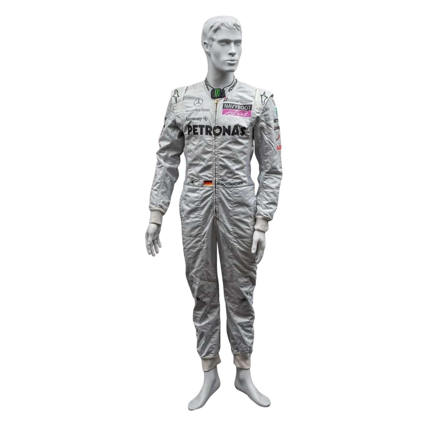 Front view of Michael Schumacher’s 2010 F1 racing suit in silver with green and black accents, featuring signature branding and structured design.