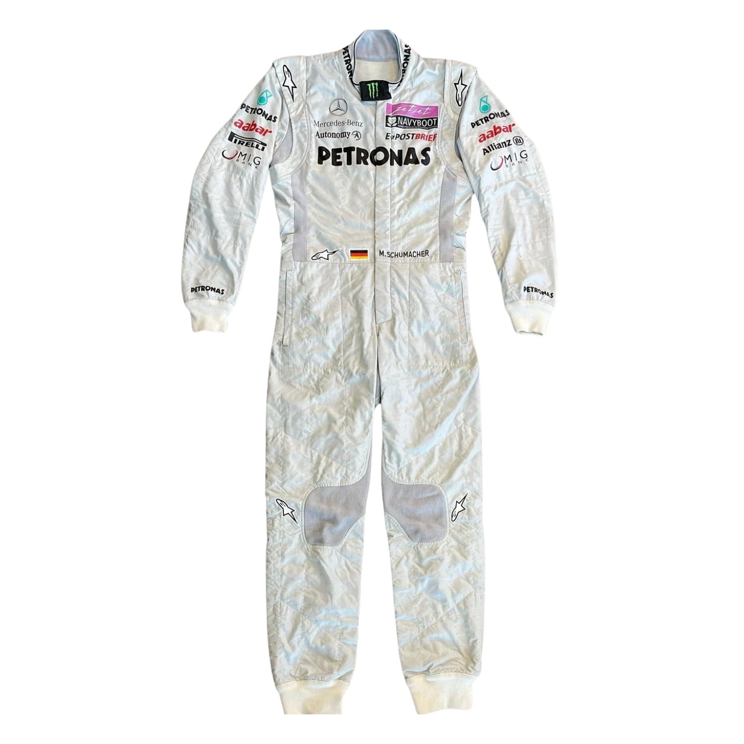 Front view of Michael Schumacher’s 2011 F1 racing suit in silver with green highlights, showcasing sponsor patches, front zip, and signature detailing.