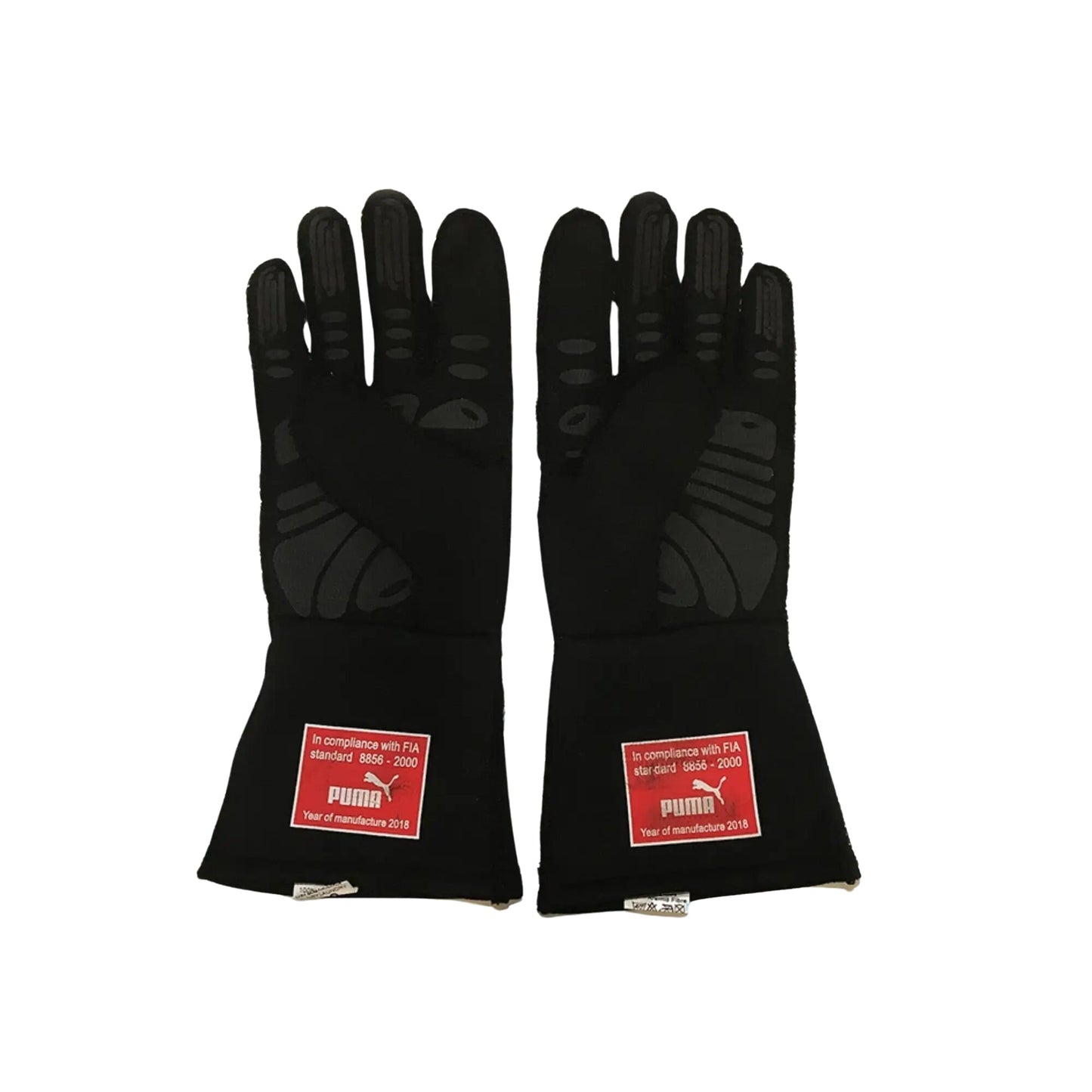 Pair of black Sebastian Vettel 2018 F1 racing gloves with FIA compliance labels on a white background