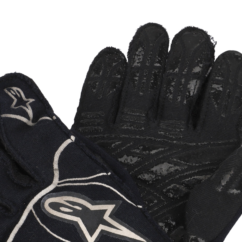 Close up of a Valtteri Bottas 2015 Black gloves with a logo on a white background