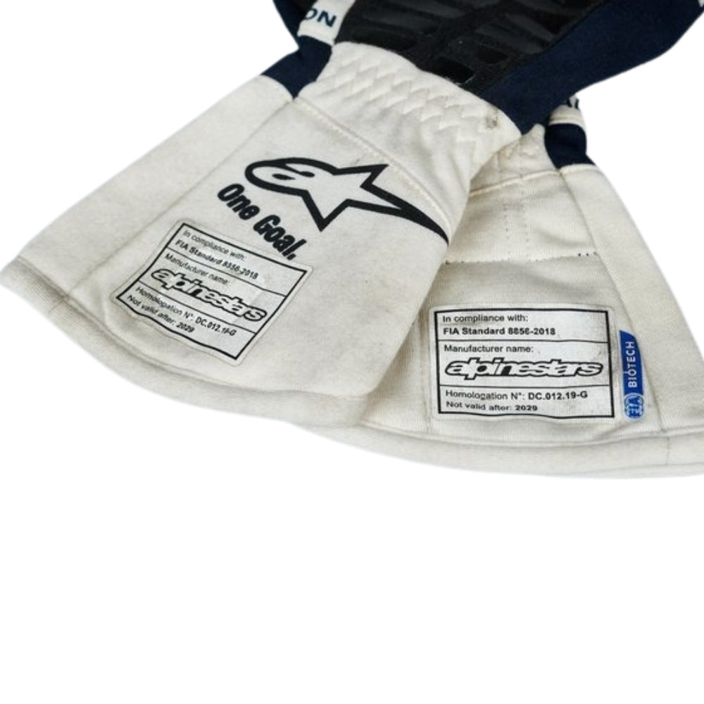 Close-up of a white Yuki Tsunoda 2022 F1 Racing gloves with visible branding on a white background